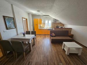 sala de estar con sofá, mesas y cocina en Apartments Lujić, en Crikvenica