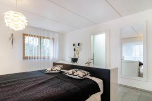 Schlafzimmer mit einem schwarzen Bett und einem Spiegel in der Unterkunft Turmalin in Überlingen