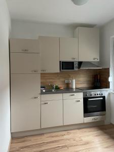 una cocina blanca con armarios blancos y fregadero en Seiersberg en Seiersberg