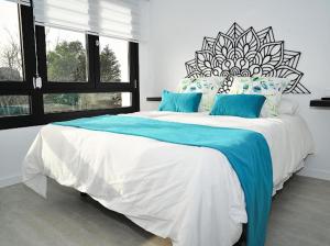 1 dormitorio con 1 cama grande con almohadas azules en atardeceres lofts, en Benaocaz