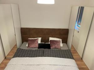 Cama en habitación pequeña con 2 almohadas en Seiersberg en Seiersberg