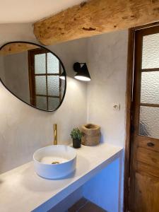 La salle de bains est pourvue d'un lavabo et d'un miroir. dans l'établissement Authentique Mazet et sa fontaine en Provence, à Fontvieille