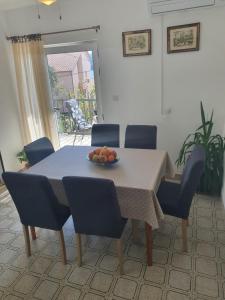Apartment Marija Marina في مارينا: طاولة غرفة الطعام مع وعاء من الفواكه عليها