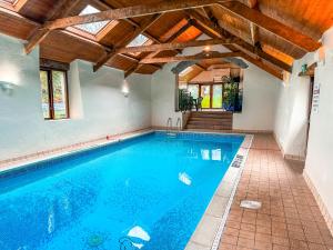 - une piscine dans une maison dotée d'un plafond en bois dans l'établissement Fern Cottage, Triscombe Farm Cottages, à Wheddon Cross