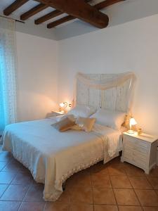 a bedroom with a white bed and two night stands at Shabby House in Podere Modello