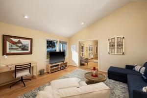 ein Wohnzimmer mit einem Sofa und einem TV in der Unterkunft Casa Costera in Santa Barbara
