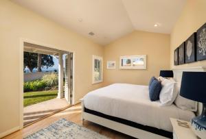 a bedroom with a large bed and an open door at Casa Costera in Santa Barbara