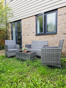 three wicker chairs and a table in front of a building at Stylish 3 Bedrooms & 2 Bathrooms House, Free Parking! in Cambridge