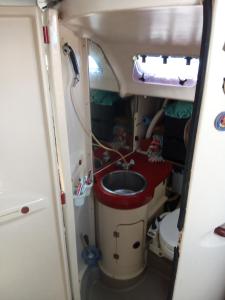 ein Badezimmer mit einem Waschbecken und einem WC in einem Wohnwagen in der Unterkunft Chambre sur un voilier in Sainte-Anne