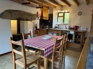 a kitchen with a table with a red and white checkered table cloth at Llanerch in Bala