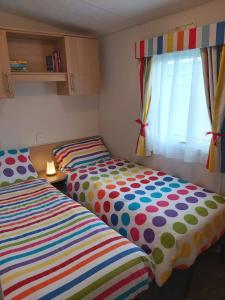 two twin beds in a room with a window at Endless Summer in Barnstaple