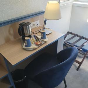 uma secretária com comodidades para preparar café e uma cadeira azul em Kyriad Villefranche Sur Saone em Villefranche-sur-Saône