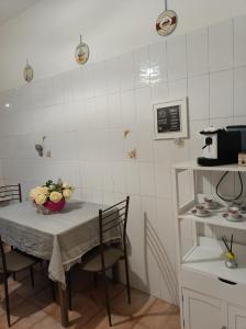 a kitchen with a table with a vase of flowers on it at Gregorihouseroma in Rome