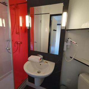 a bathroom with a toilet and a sink and a mirror at Kyriad Villefranche Sur Saone in Villefranche-sur-Saône