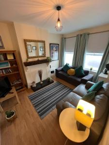 uma sala de estar com um sofá e uma mesa em Private Home Titanic History em Belfast