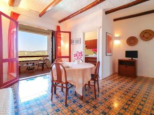 uma sala de jantar com mesa e cadeiras em Baja Sardinia Pool Residence em Baja Sardinia