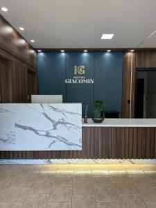 eine Lobby mit Marmortheke und blauer Wand in der Unterkunft Hotel Giacomin in Dois Lajeados