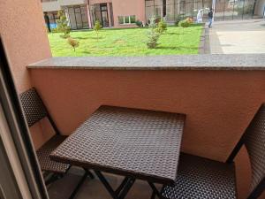 un balcone con tavolo, 2 sedie e bancone di Apartment Dastidi a Kosovo Polje