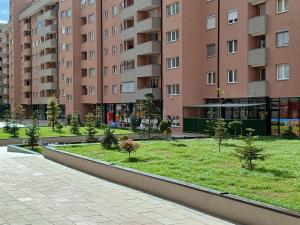 un parco di fronte a un grande condominio di Apartment Dastidi a Kosovo Polje
