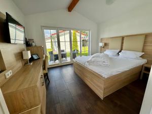 een slaapkamer met een groot bed en een raam bij Havellandhalle Resort in Seeburg