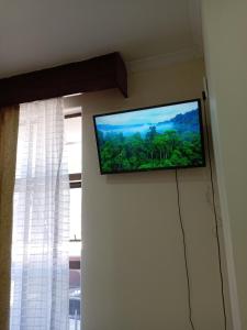 TV de pantalla plana colgada en una pared junto a una ventana en Beyond New House, en Ciudad del Cabo