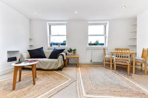 ein Wohnzimmer mit einem Sofa und einem Tisch in der Unterkunft Royal Kensington 1 Bedroom Apartment in London