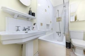 ein weißes Badezimmer mit 2 Waschbecken und einem WC in der Unterkunft Royal Kensington 1 Bedroom Apartment in London