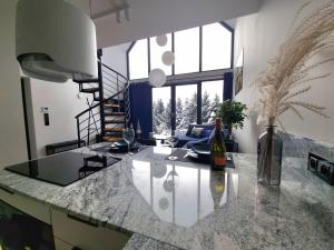 a kitchen with a marble counter top and a staircase at Green House Jugów in Jugów