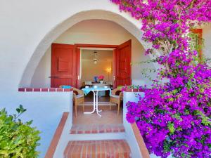 um quarto com uma mesa e flores roxas em Baja Sardinia Pool Residence em Baja Sardinia