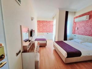 Cette chambre comprend deux lits et un bureau. dans l'établissement Perlo Hotel City, à Antalya