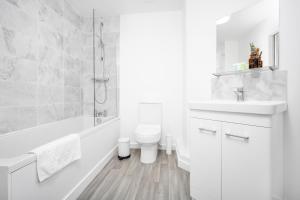 a white bathroom with a toilet and a sink at New 2 Bedroom Deluxe Apartment - Parking - Wifi & Netflix - Top Rated - 50C in Sleightholme +13 photos