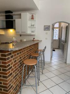 a kitchen with a brick counter and stools at La grande Amiénoise de 7 chambres, quartier calme et résidentiel in Amiens