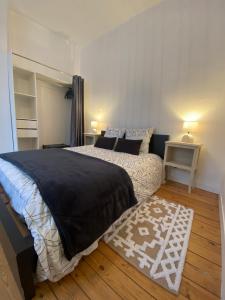 a bedroom with a large bed and a rug at La grande Amiénoise de 7 chambres, quartier calme et résidentiel in Amiens
