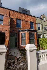 a brick house with a green door and a fence at Boutique Stays at 78 in Bangor