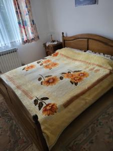 a bed with a quilt with flowers on it at Vila Garanga in Luke