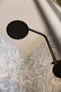 a black lamp on a ceiling with a wall at Boutique Stays at 78 in Bangor