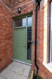 a green door on the side of a brick building at Boutique Stays at 78 in Bangor