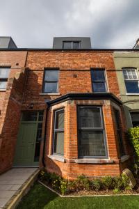 a brick building with a green door and a green garage at Boutique Stays at 78 in Bangor