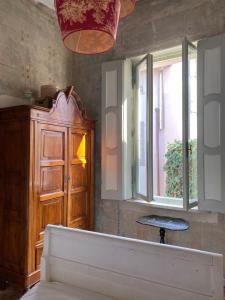 Cette chambre comprend une armoire en bois et une fenêtre. dans l'établissement 7.Frecavalli Appartamento in Palazzo d'epoca, à Crema