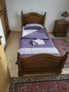 a bedroom with a wooden bed and a rug at Vila Garanga in Luke