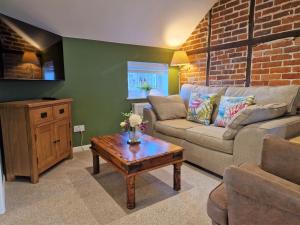 a living room with a couch and a coffee table at The Hayloft in Ivinghoe