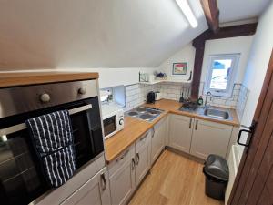a small kitchen with white cabinets and a sink at The Hayloft in Ivinghoe