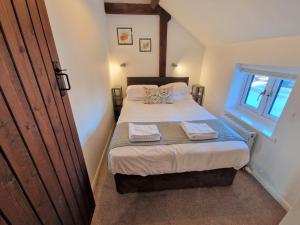 a small bedroom with a bed and a window at The Hayloft in Ivinghoe