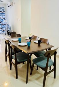 un tavolo e sedie in legno con piatti e ciotole di Melur D’Homestay Putrajaya a Putrajaya