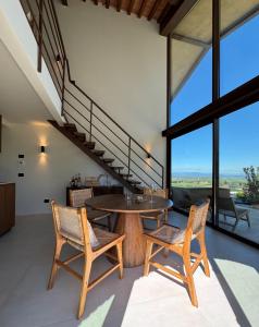 ein Esszimmer mit einem Tisch, Stühlen und einer Treppe in der Unterkunft Spereto Pendolino, pool, nature and view in Montaione