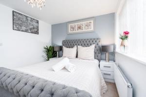 sypialnia z dużym łóżkiem z białą pościelą w obiekcie Modern House with Parking and Garden w mieście Doncaster