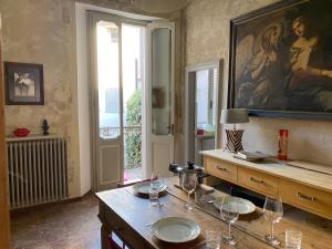 a room with a table with wine glasses and a painting at 7.Frecavalli Appartamento in Palazzo d'epoca in Crema