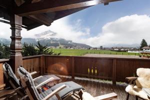 a deck with chairs and a fireplace and a mountain at Haus Kexel in Sankt Johann in Tirol
