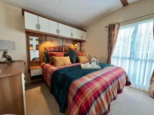 Un dormitorio con una cama grande y una ventana en 29 Morningside at Southview in Skegness - Park Dean resorts, en Lincolnshire