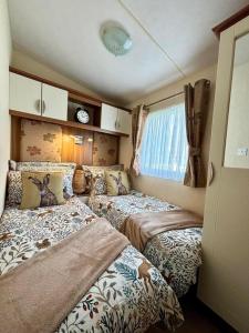 29 Morningside at Southview in Skegness - Park Dean resorts في Lincolnshire: غرفة نوم بسريرين في غرفة صغيرة